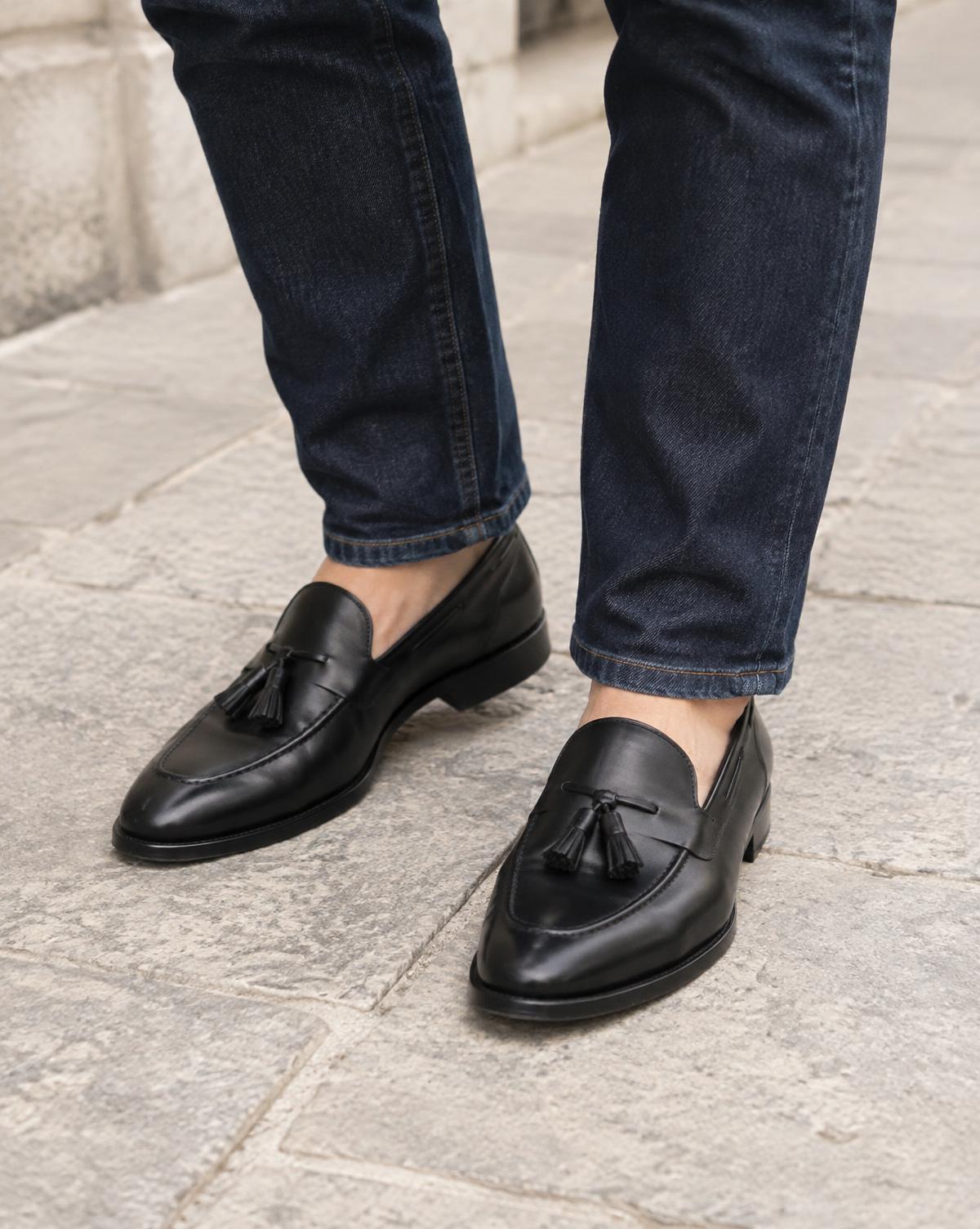 The Tassel Loafer in black calf, worn